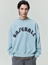 male model wearing sun-faded light blue heavyweight cotton fleece sweatshirt with bold black "BASEBALL" text on front