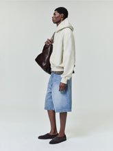 side view of model wearing relaxed fit classic blue indigo denim utility shorts with front and back pockets