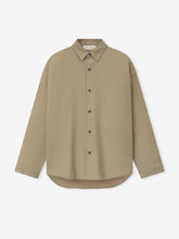 Front view of beige long-sleeve button-up shirt with pointed collar and rounded hem on white background