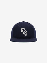 Fear of God Essentials 59FIFTY Retro Fitted FG Cap in deep navy fabric with a white embroidered interlocking "FG" emblem on the front and a structured flat brim.