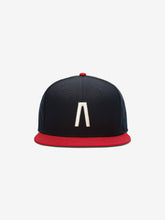 Fear of God Essentials 59FIFTY Athletics Cap featuring a navy blue crown with a prominent white embroidered minimalist symbol on the front and a contrasting red flat brim and button.