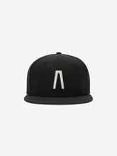 Fear of God Essentials 59FIFTY Athletics Cap featuring a solid black crown with a raised metallic silver minimalist emblem centered on the front and a flat black brim.