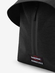 Essentials Backpack in black close up showing a vertical zipper curved top edge and embroidered Essentials logo patch on textured fabric against a white background