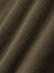 Detailed close-up of smooth, faded brown cotton fabric showing fine knit texture and soft folds