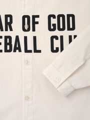Close-up of natural off-white shirt front with visible buttons and black bold text partially reading "Baseball Club