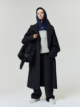 Bears 90s Relaxed Hoodie layered under a black overcoat with black trousers and white sneakers shown on a model as a Tops fashion product view