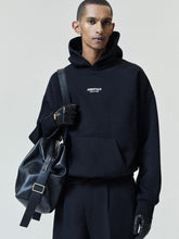 Essentials FW26 Classic Hoodie in black styled with matching trousers black gloves and a leather shoulder bag featuring a small Fear of God chest logo Tops