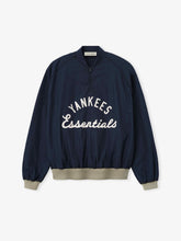 Yankees Half Zip Pullover in dark navy with beige ribbed cuffs and hem, featuring a half-zip front and white "Yankees Essentials" embroidered text across the chest.