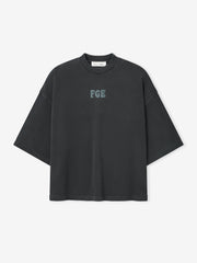 Heavy Jersey Merch Tee in a washed iron grey tone with a relaxed oversized fit, featuring a small textured "FGE" logo centered on the chest for a minimalist casual top.