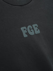 Heavy Jersey Merch Tee in a washed dark grey tone with a soft texture, featuring a small raised "FGE" logo on the chest for a sleek, minimalistic casual top.