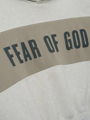 Cropped Relaxed Panelled Hoodie featuring a soft vanilla heather fabric with a wide muted taupe panel across the chest displaying bold black Fear of God lettering for a stylish streetwear look.