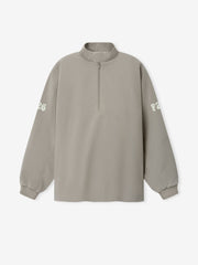 Half Zip Track Jacket in a muted taupe shade featuring a relaxed fit, long sleeves with subtle white printed lettering on each arm, and a front half-zip closure for versatile outerwear.
