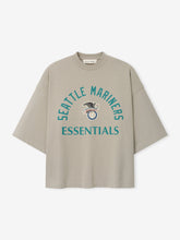 Mariners American League Merch Tee in muted gray with wide short sleeves, featuring a teal Seattle Mariners Essentials logo and vintage-inspired eagle graphic, designed as a casual top.