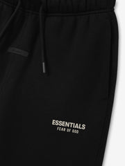 Kids Essentials FW26 Classic Sweatpant in black close up showing drawstring waistband side pocket and Essentials Fear of God logo detail Bottoms