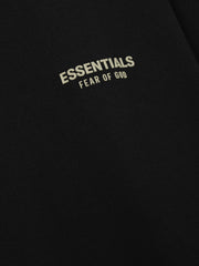 Essentials FW26 Classic Tee close up of black fabric featuring a cream Essentials Fear of God logo detail with soft texture Tops