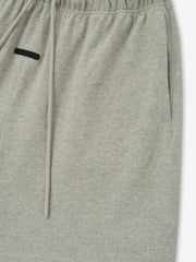 Essentials FW26 Classic Heavy Jersey Short in heather gray close up showing elastic waistband drawstring side pocket and subtle tonal logo detail Bottoms