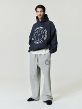 navy oversized hoodie with circular NBA Essentials text and basketball graphic worn with gray sweatpants with matching logo