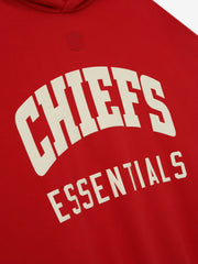 Close-up of red Chiefs Sport Hoodie showing cream Essentials text with subtle embossed NFL shield above the chest