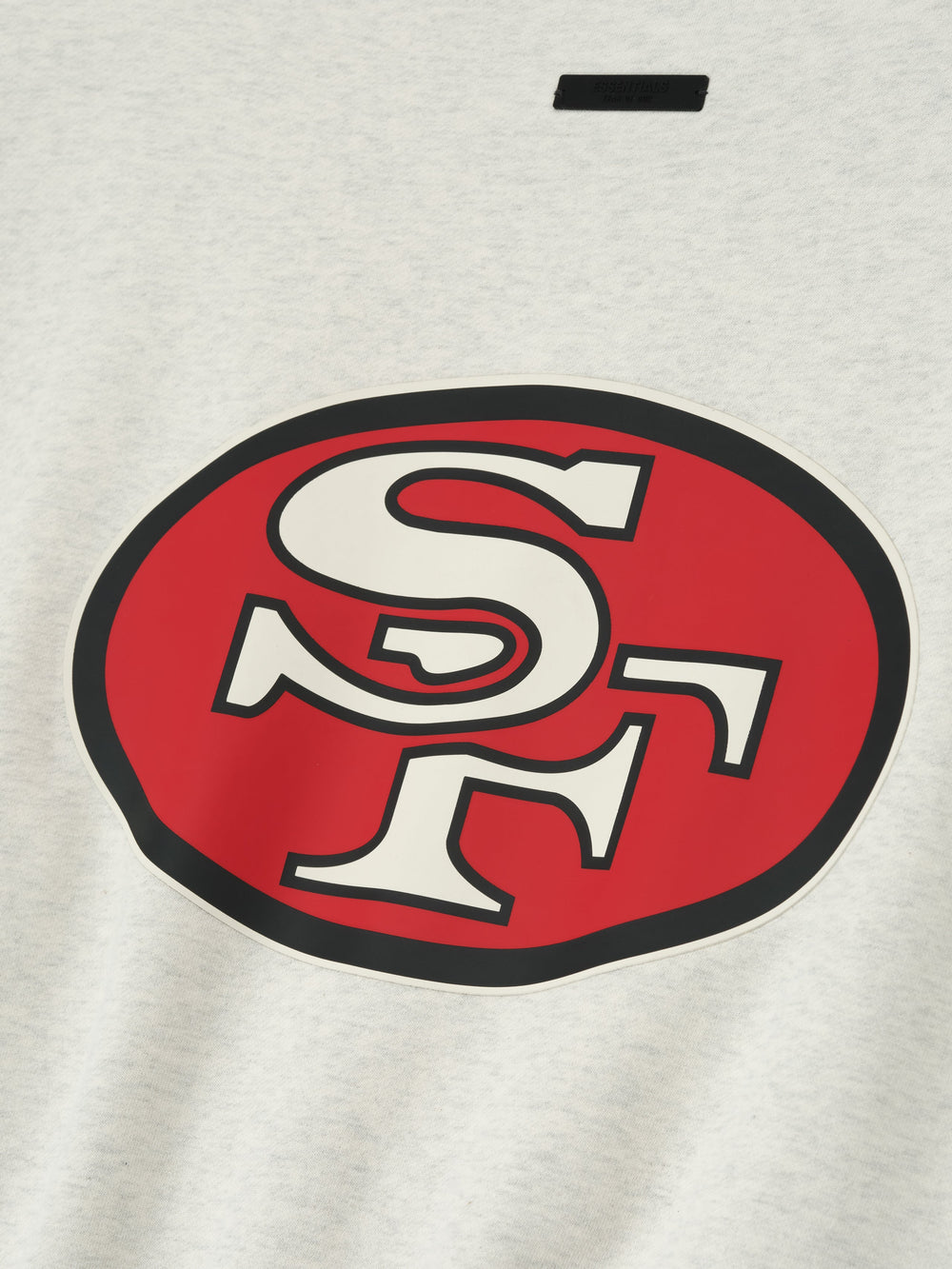 Close-up of the Forty Niners Sport Crewneck featuring a large red oval with white "SF" letters outlined in black on light gray fabric, highlighting the soft texture.