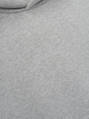 Close-up of a gray hoodie with essentials embroidery script
