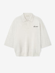 off-white heavy merino knit polo with 3/4 sleeves, relaxed fit, classic collar, and black Essentials script embroidery on chest