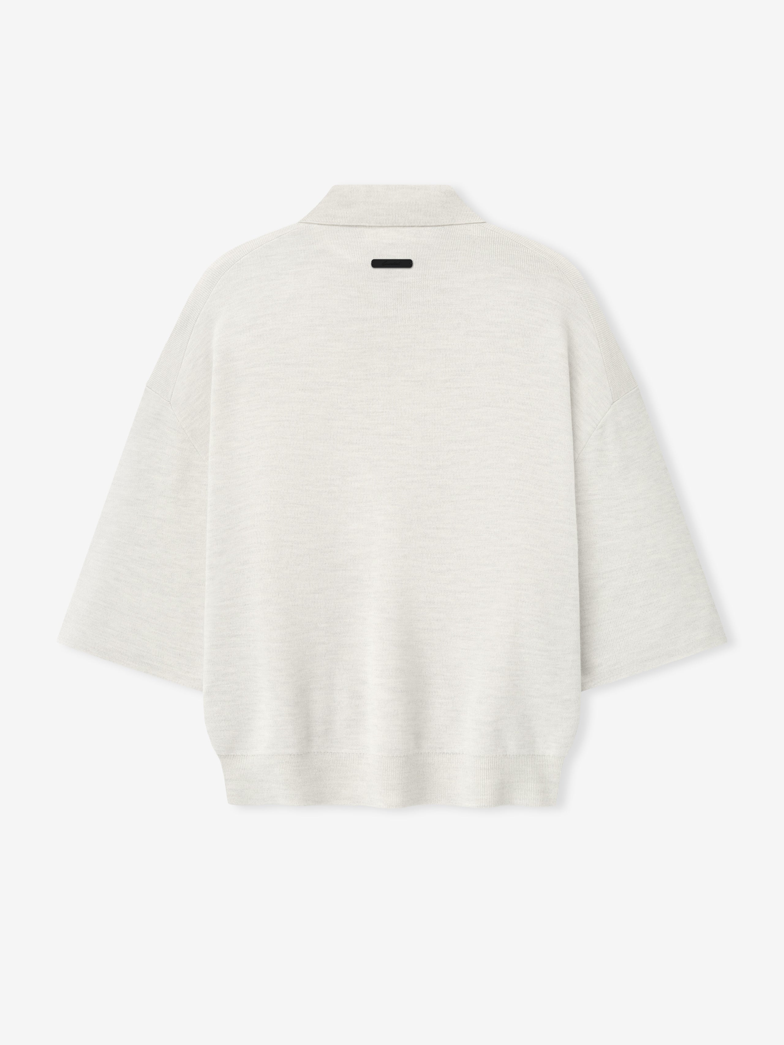 back view of off-white heavy merino knit polo with 3/4 sleeves and relaxed fit featuring small black label on neckline