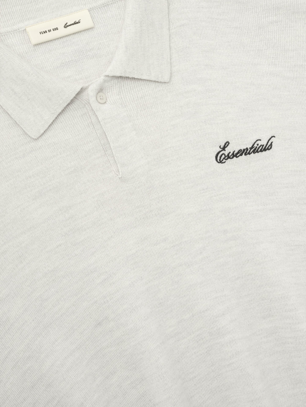 off-white heavy merino knit polo with classic collar and black Essentials script embroidery on chest