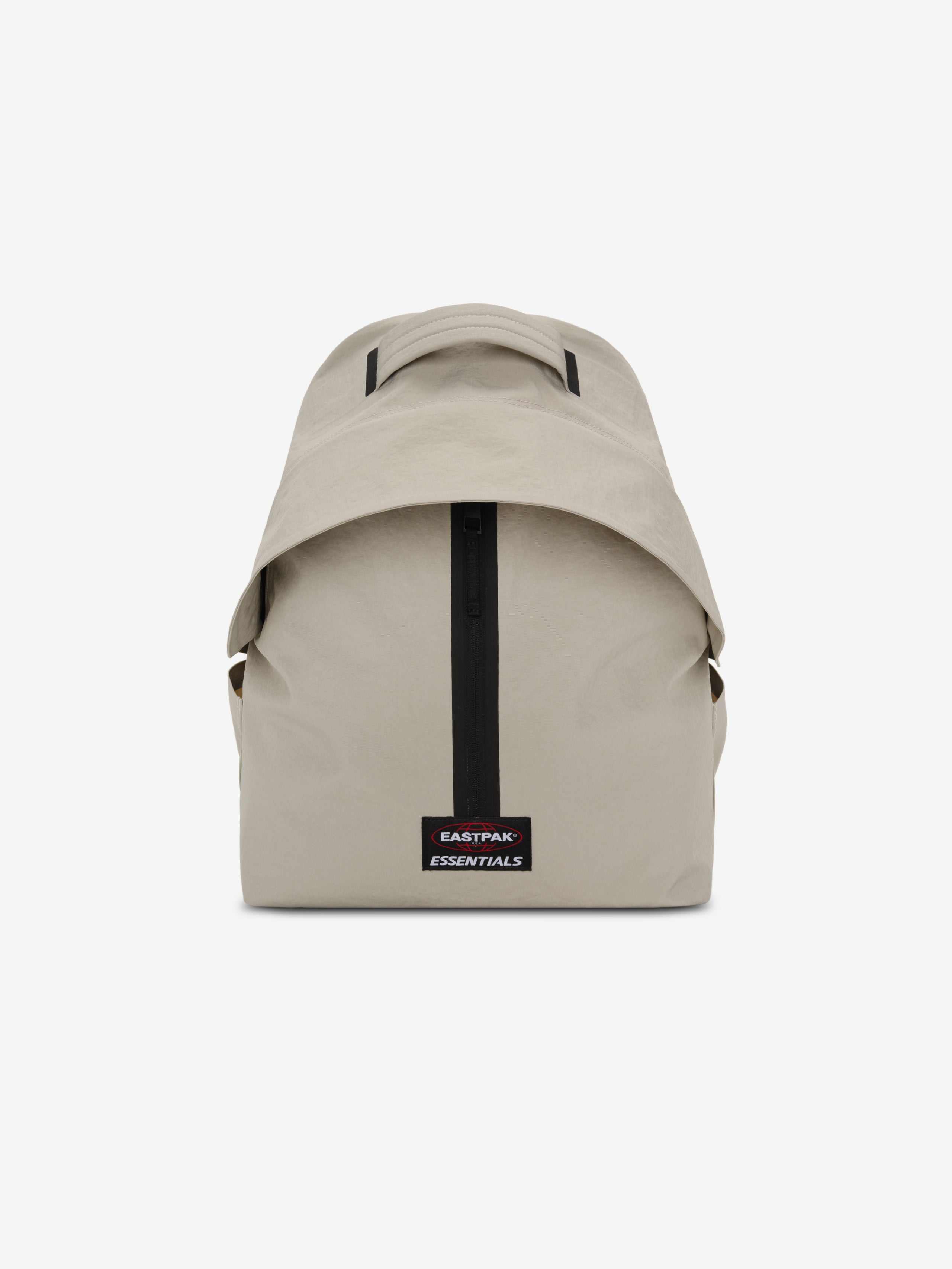 Essentials Backpack in beige shown from the front with a top carry handle central black zipper and rectangular logo patch on a clean white background