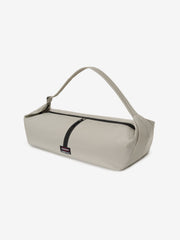 ESSENTIALS SHELL BAG LARGE in light beige with a curved shoulder strap black zipper and small woven logo label on a clean white background