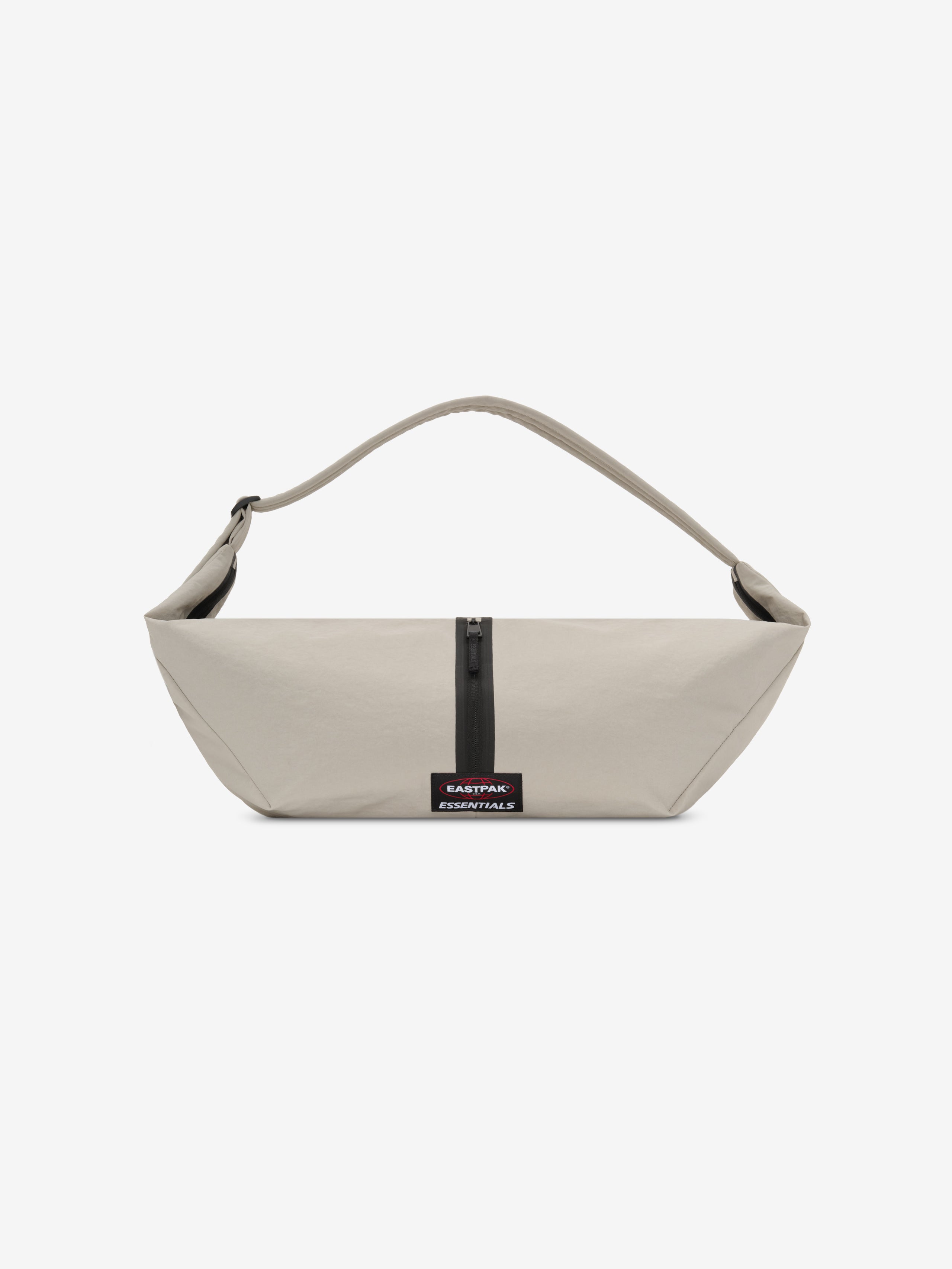 Essentials Shell Bag in light beige with a curved shoulder strap central black zipper and small woven label displayed against a clean white background