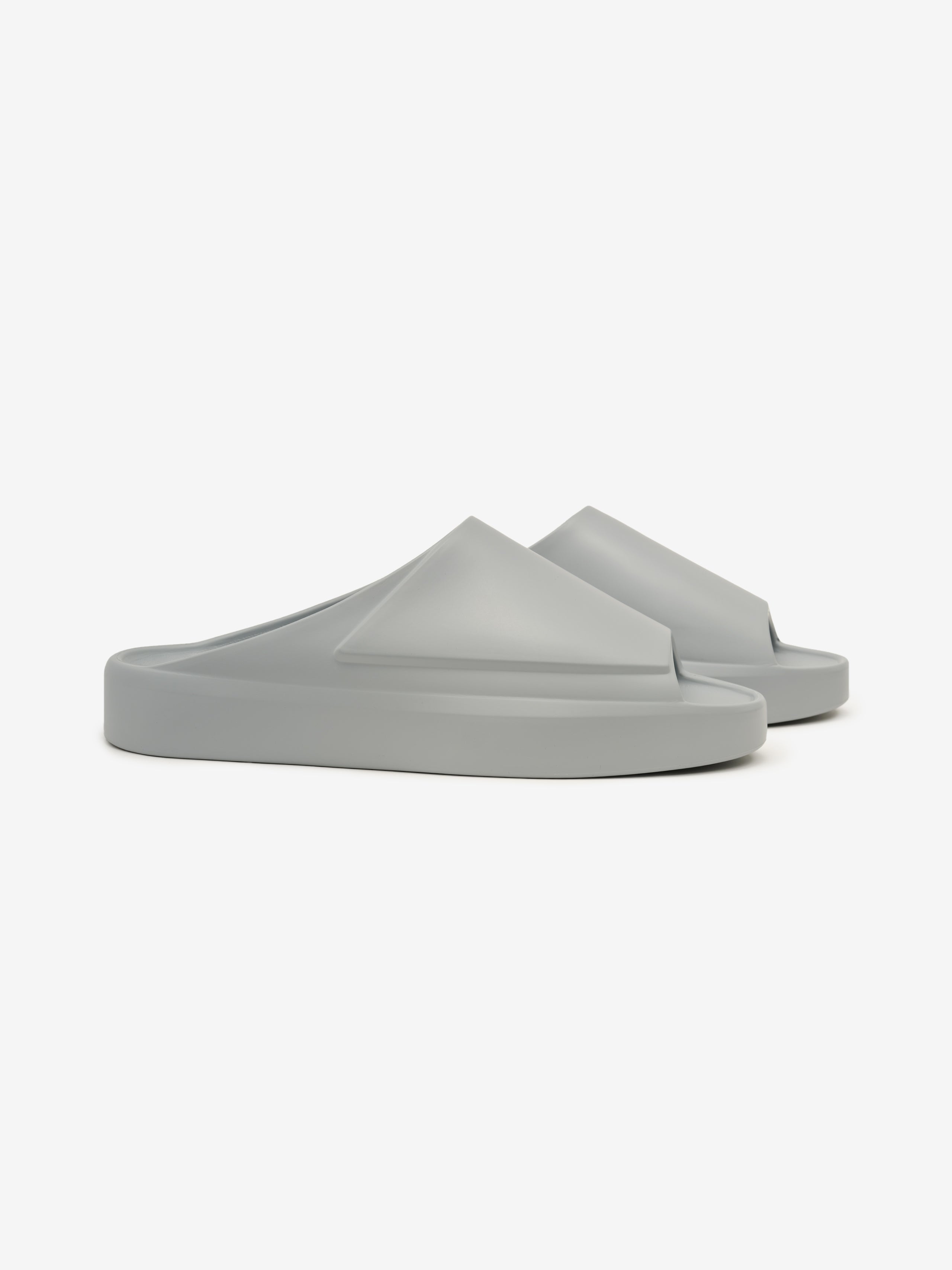 Essentials Los Feliz footwear in a muted grey tone, featuring a smooth, slip-on design with a futuristic molded upper and thick cushioned sole for relaxed casual wear.
