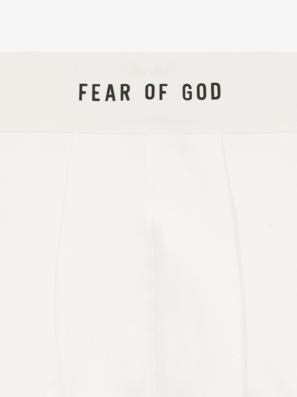 close-up of white rib-knit brief with plush elastic waistband branded Fear of God in black text