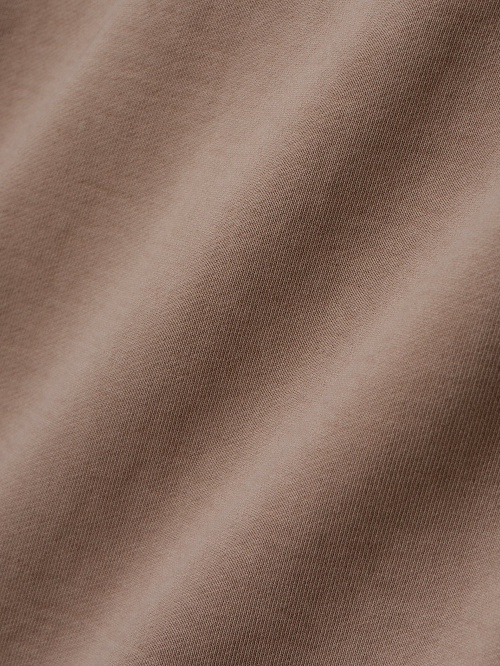 close-up of taupe heavyweight cotton fleece fabric with soft texture and sunfade garment wash finish