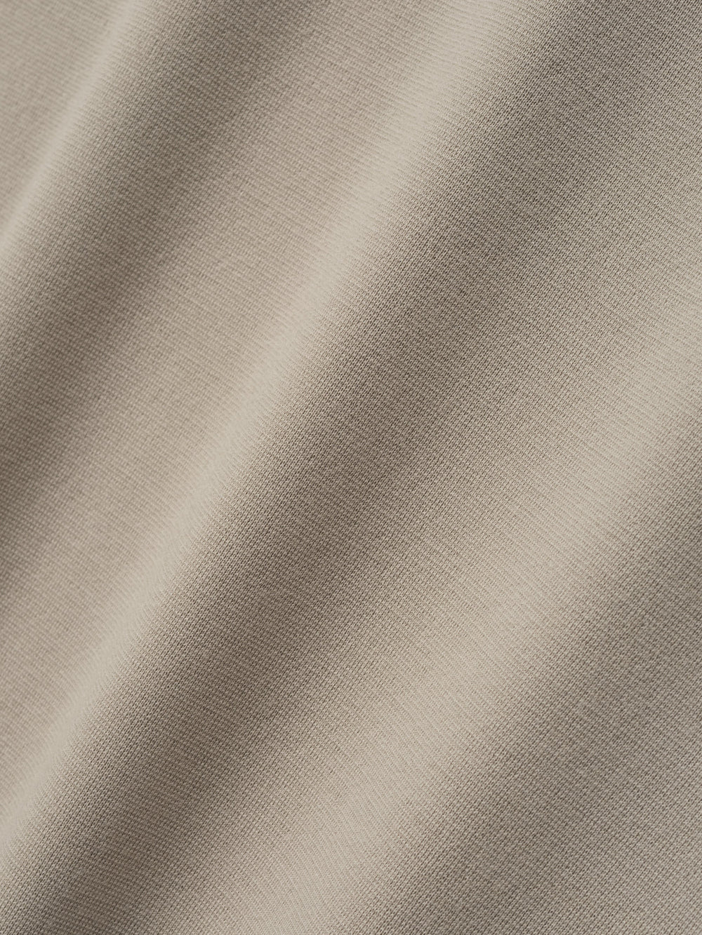 close-up of light beige merino Milano stitch fabric with smooth texture and fine-knit surface in soft natural color