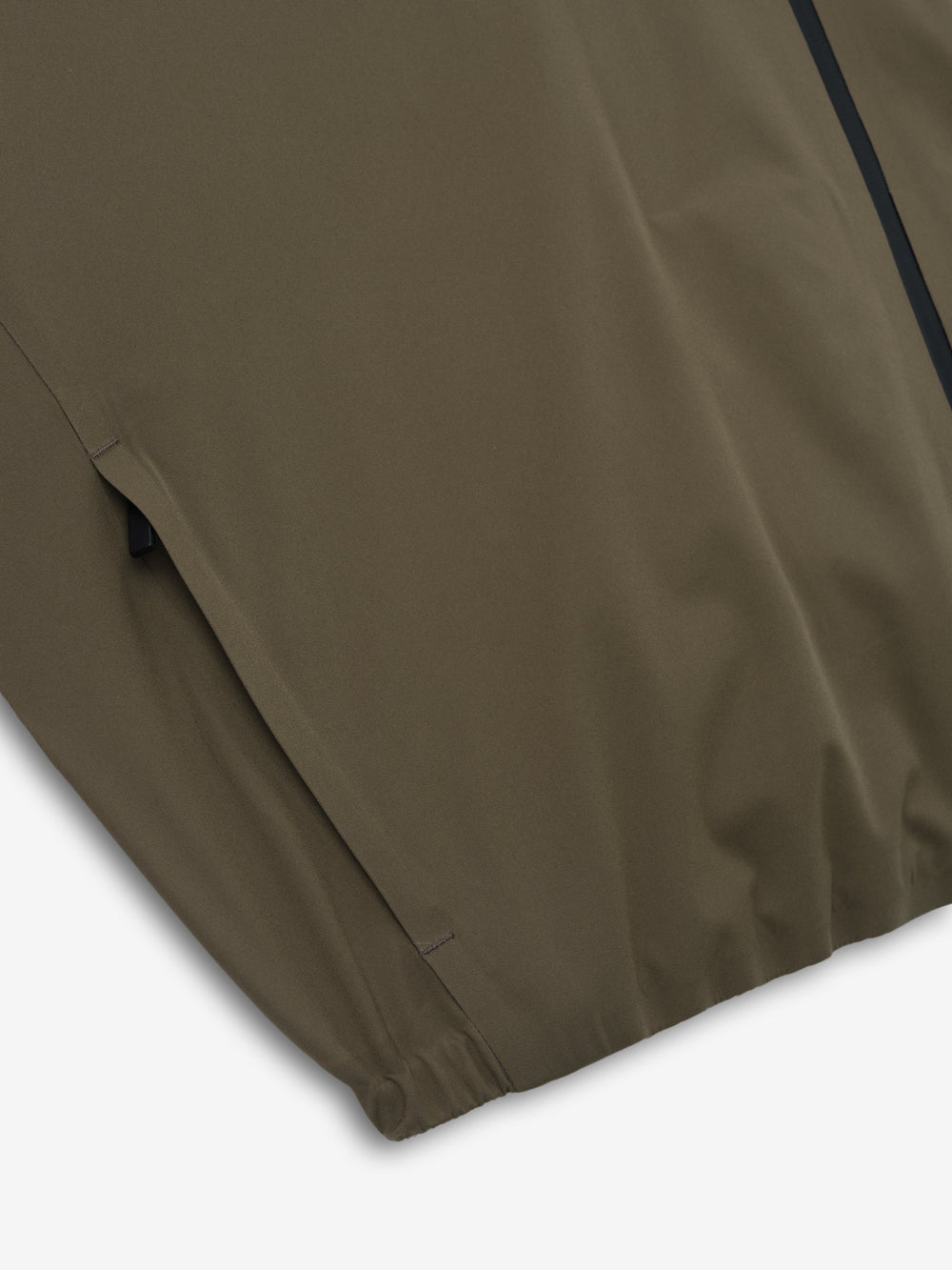 close-up of olive bonded nylon fabric with elasticated hem detail on tech track jacket sleeve