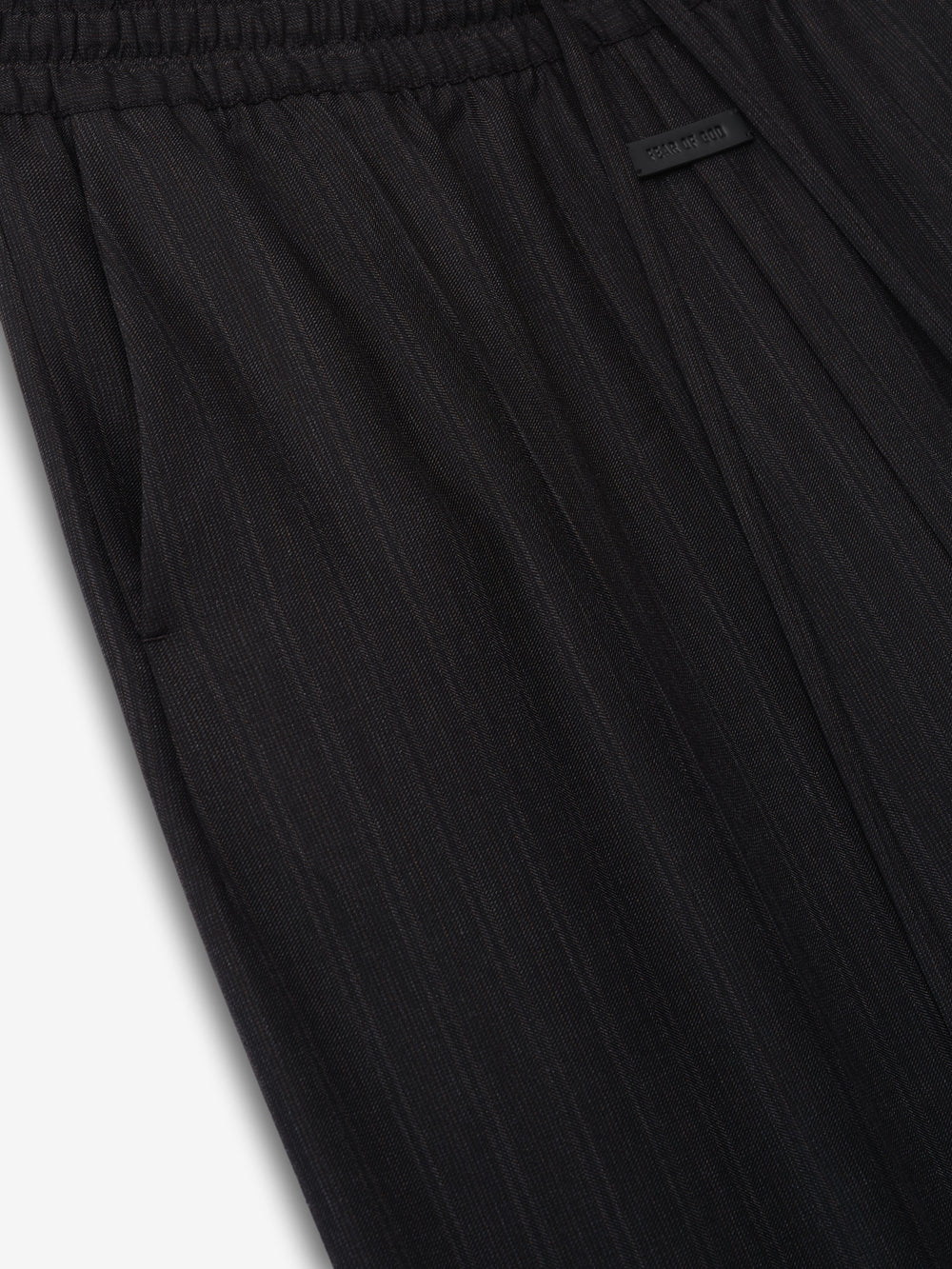 close-up of black striped wool fabric on wide-leg pants with elastic waistband and side pocket detail