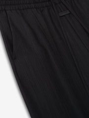 close-up of black striped wool fabric on wide-leg pants with elastic waistband and side pocket detail