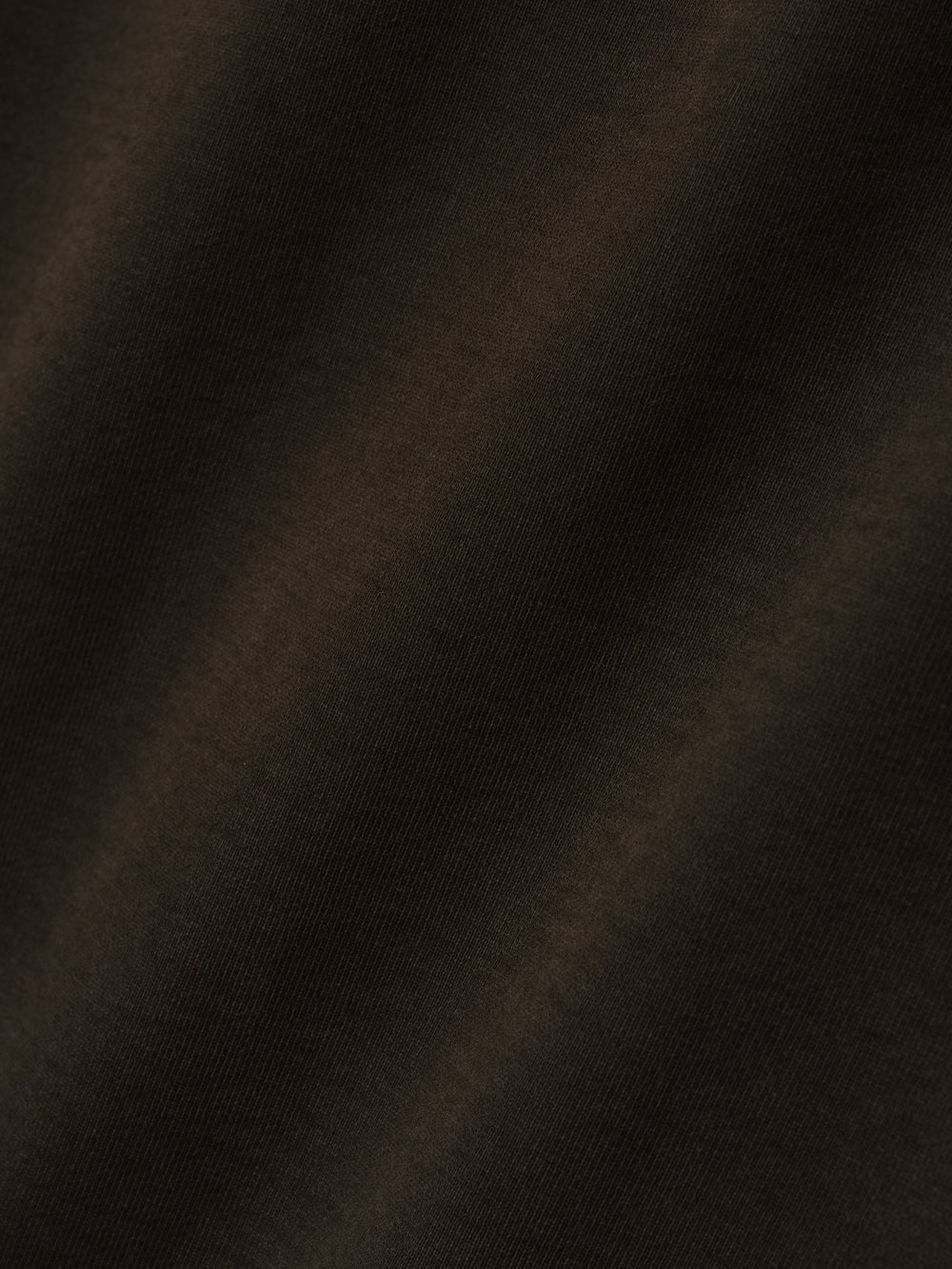 close-up of dark brown heavyweight cotton fleece fabric with soft texture and vintage garment wash finish