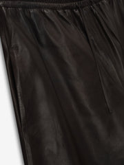 close-up of black full-grain calfskin leather baggy shorts with elastic drawstring waistband and smooth texture
