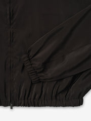 close-up of black lightweight crinkle viscose track jacket cuff and hem with elasticated ribbing and smooth matte finish