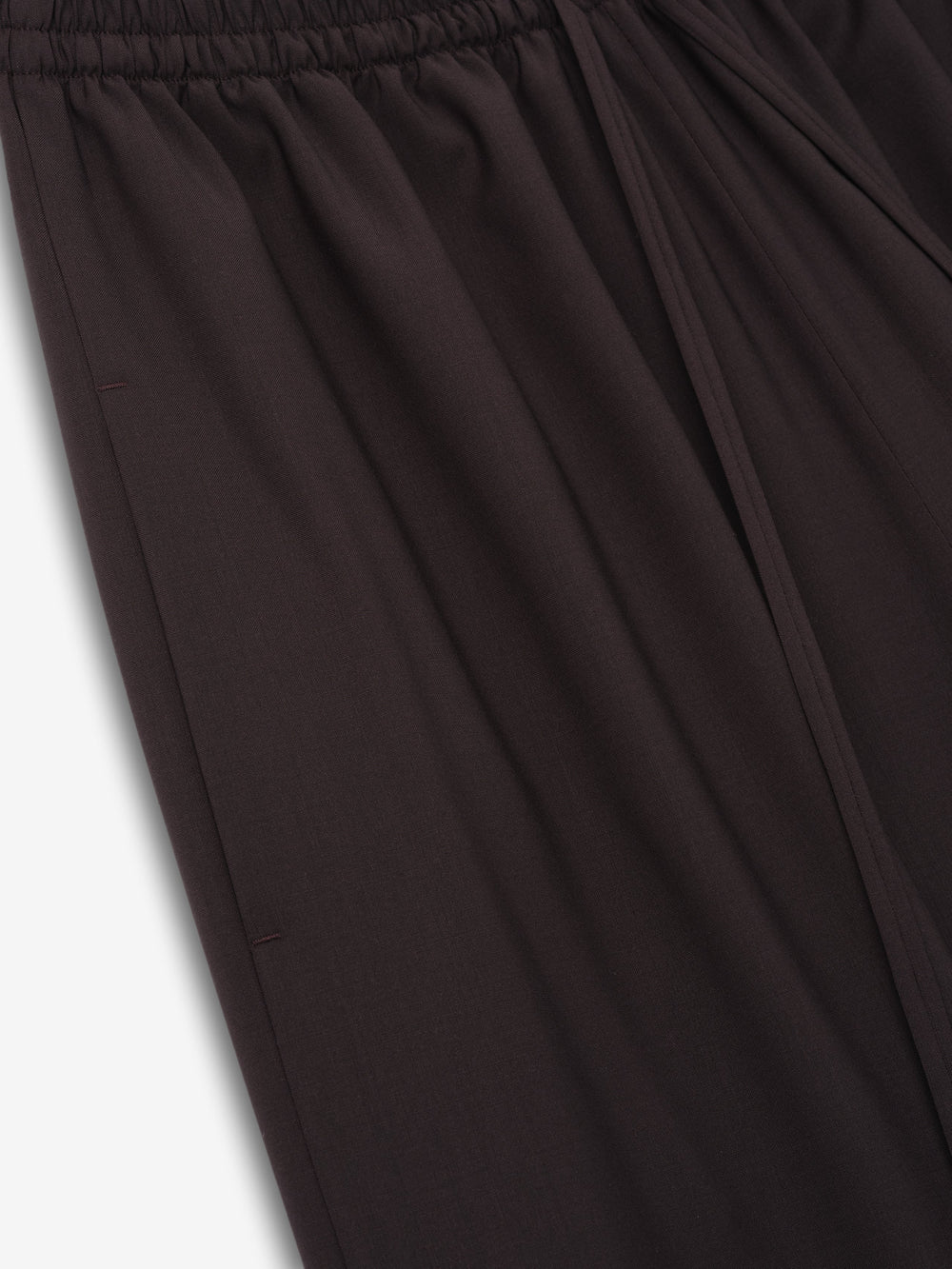 close-up of dark superfine wool canvas drawstring pants with elasticated waistband and relaxed wide-leg fit for women