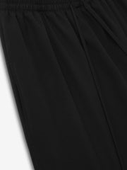 close-up of black compact lightweight rip-stop virgin wool drawstring pants with elasticated waistband and wide-leg design