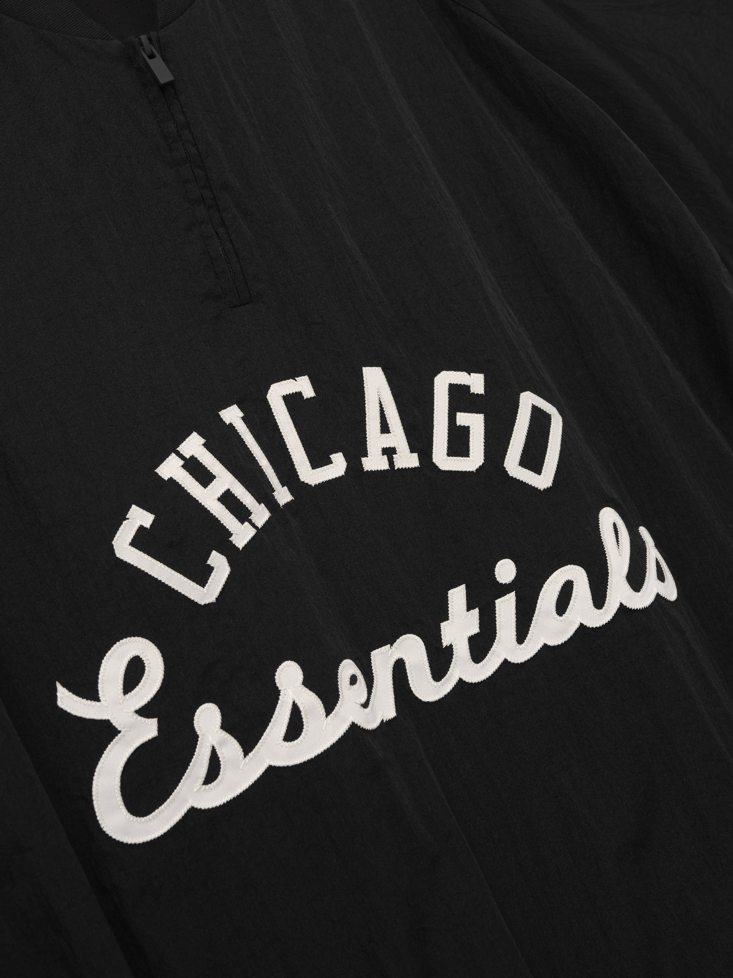 White Sox Half Zip Pullover in black fabric featuring white "Chicago Essentials" embroidered script on the chest with a quarter zip for versatile casual outerwear.