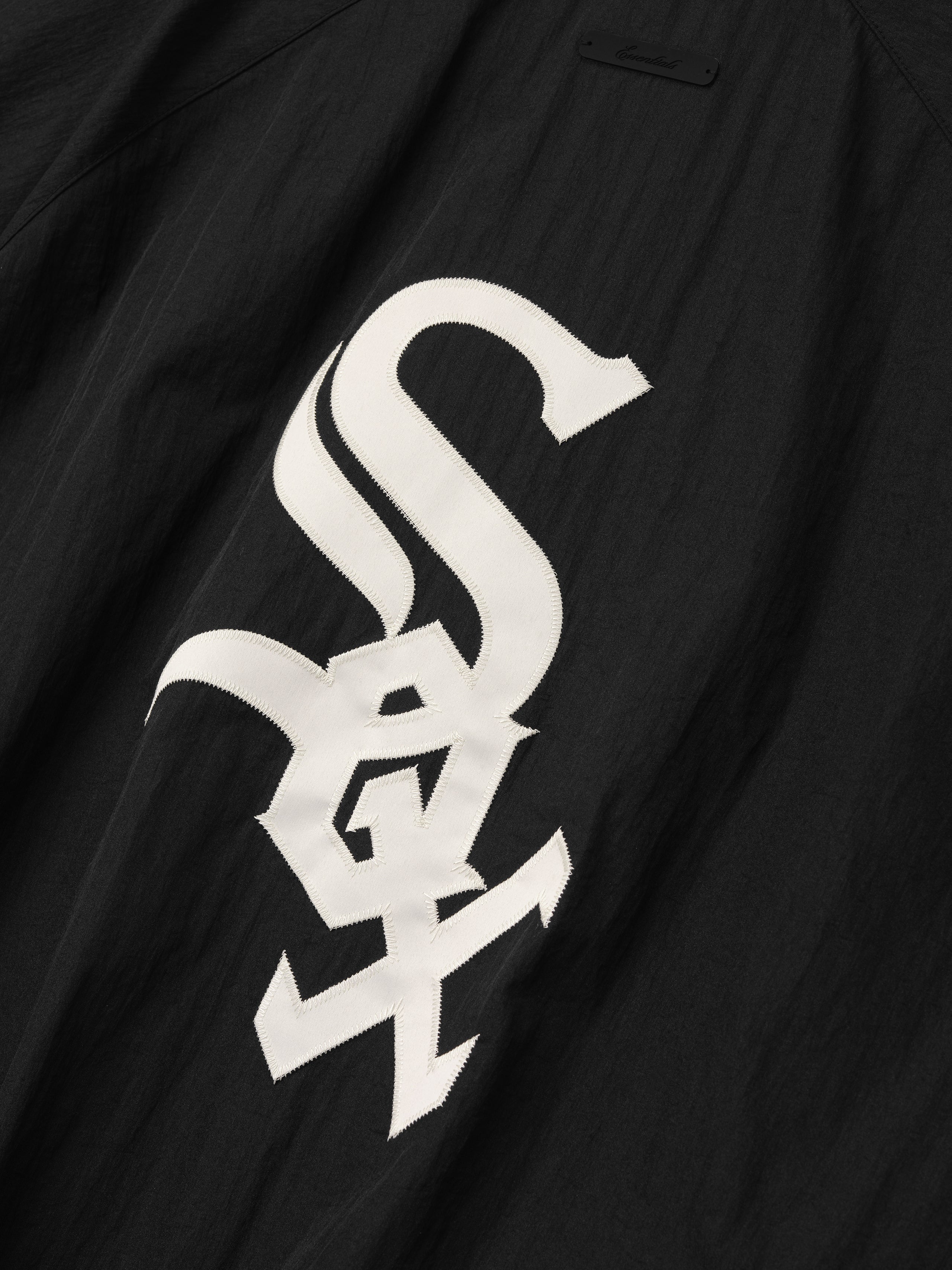 White Sox Half Zip Pullover in black showcasing a large, bold white team logo on the back, crafted with textured fabric for stylish outerwear appeal.