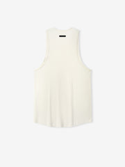 Ribbed Essential Tank in a soft ivory shade, featuring a smooth ribbed fabric with a relaxed cut and wide armholes for comfortable casual layering tops.