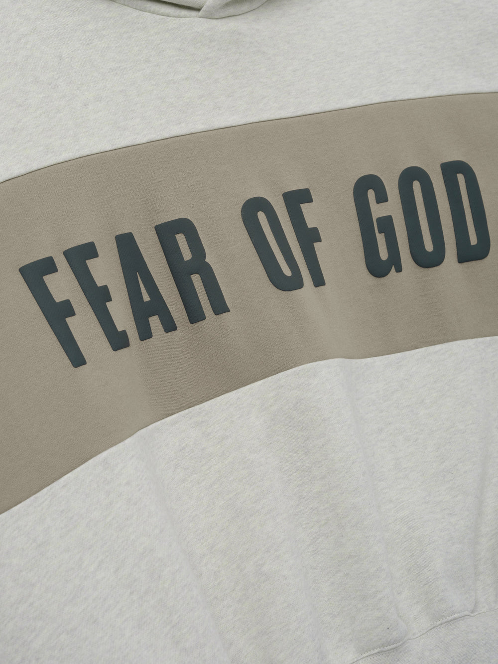 Cropped Relaxed Panelled Hoodie featuring a soft vanilla heather fabric with a wide muted taupe panel across the chest displaying bold black Fear of God lettering for a stylish streetwear look.