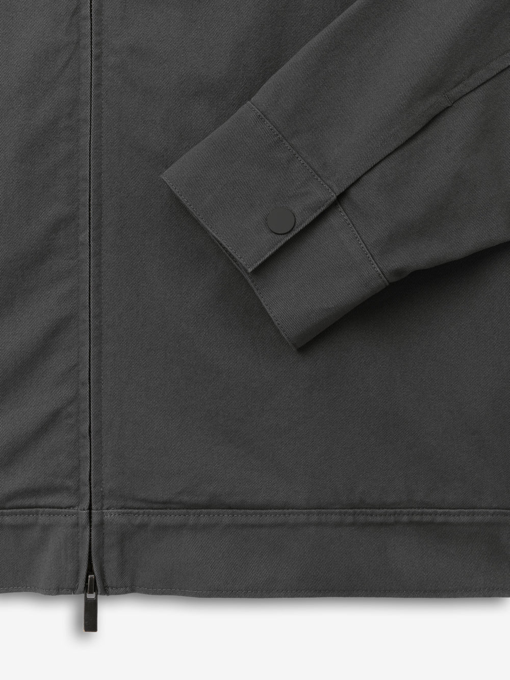 Cotton Twill Work Jacket in dark grey with a close-up of the sleeve featuring a snap button cuff and a visible zipper detail, highlighting durable, premium outerwear craftsmanship.