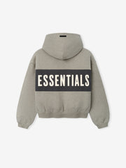 Kids Cropped Relaxed Panelled Hoodie in a muted grey tone with a contrasting dark panel across the back displaying bold "ESSENTIALS" lettering, designed as a cozy kids outerwear top.