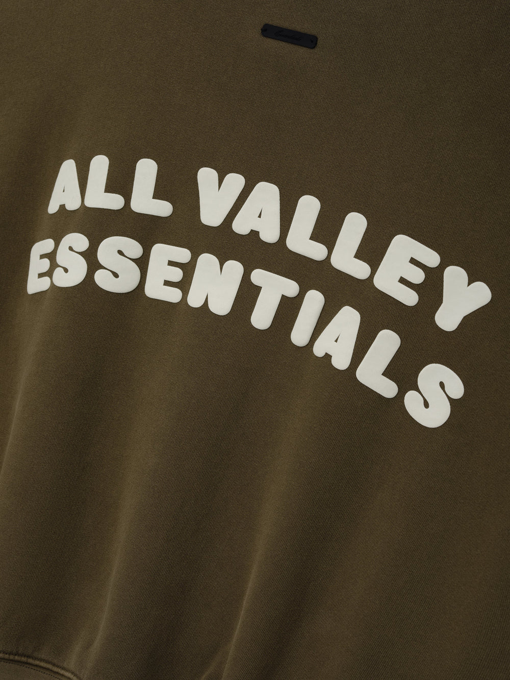 Womens French Terry Relaxed Half Zip in a muted olive green tone, featuring bold white embossed lettering “All Valley Essentials” across the chest for a stylish casual top.