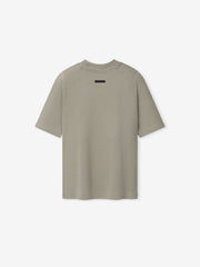 Womens Shrunken Baseball Tee in a muted sage tone featuring a relaxed fit with short sleeves and a subtle rectangular patch at the upper back, designed as a casual top.